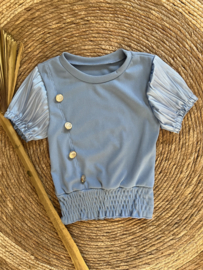 Mooi uitgewerkt shirtje met gouden knopen in het helderblauw.