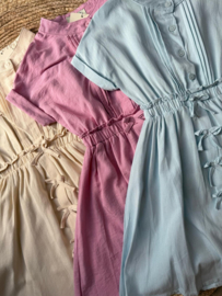 Mooi uitgewerkt jurkje met een mooie mouw en strikjes in het roze.