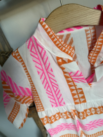 Vrolijk zomerjurkje in de kleuren fluor roze , oranje en wit .