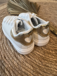 Witte sneaker met goudkleur en een hartje.