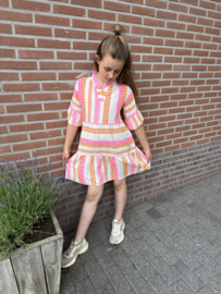 Vrolijk zomerjurkje in de kleuren fluor roze , oranje en wit .