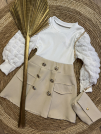 Mooi uitgewerkt jurkje met tasje in het zand met offwhite /goud.