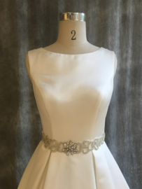 Zoë: gesofisticeerde satijnen jurk met mooie riem en prachtige rug. Prijs: 1.170€