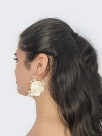 Gold-coloured earrings with a large ivory-coloured flower and real baby's breath.