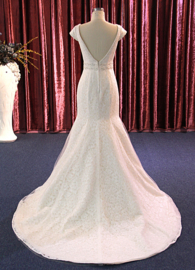 Rose: klassevolle kanten bruidsjurk met mooie boothals en korte kapmouwtjes, beide afgebiesd met mooie pareltjes. Prijs:  € 695 nu voor €500