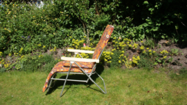Vintage tuinstoel met benen omhoog, met retro bloemprint