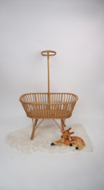 Vintage rotan poppenwieg met moderne stoffering