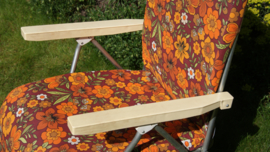 Vintage tuinstoel met benen omhoog, met retro bloemprint