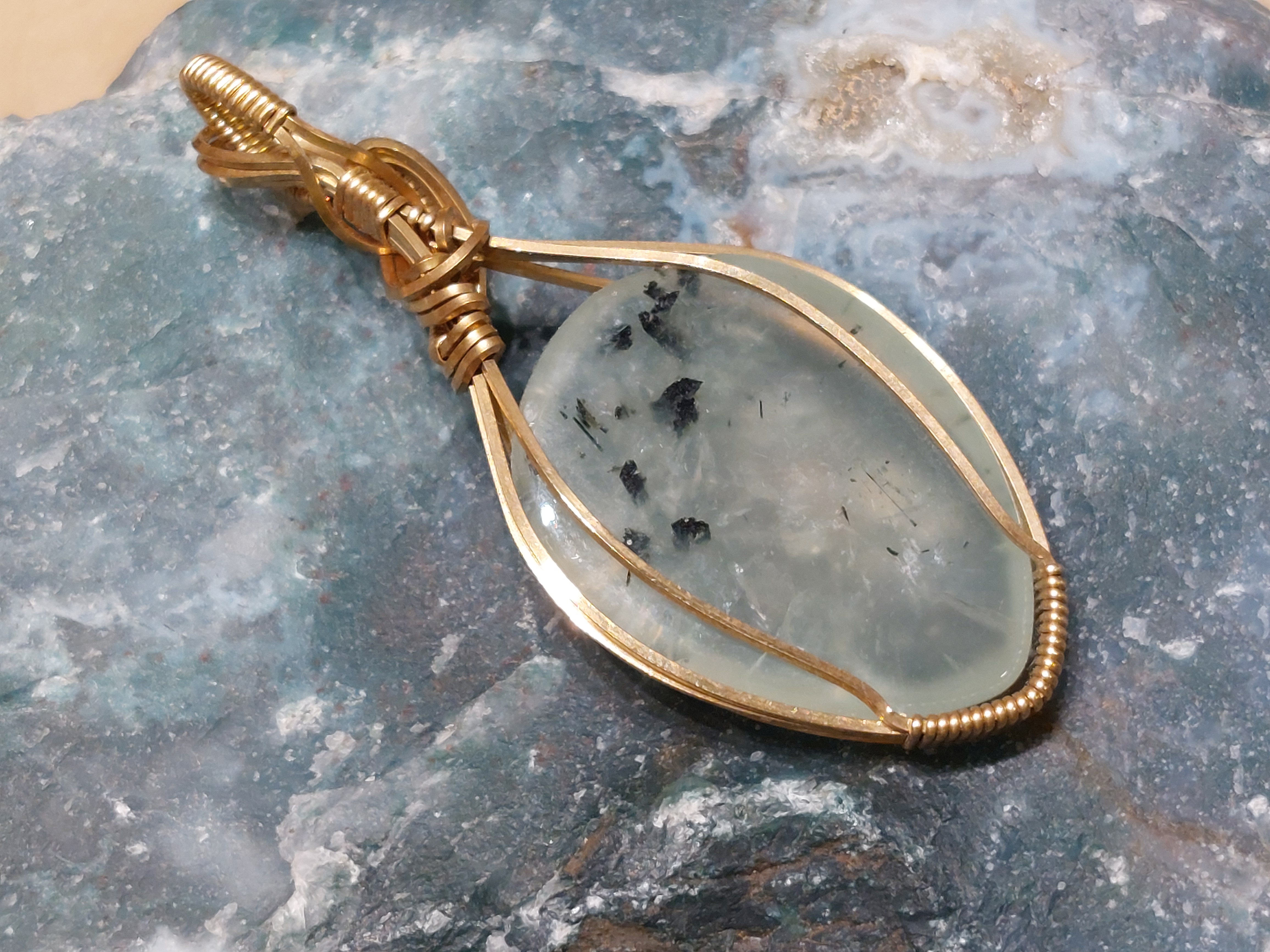 Prehniet hanger in messingdraad, gewrapped door Karin Keur