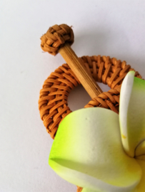 Knot speld. Bali rotan handwerk. Met zacht groene frangipani bloem. 13,5 cm lang.