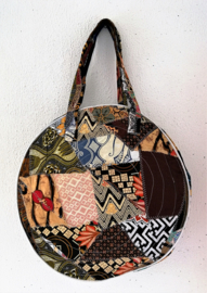 Unieke patchwork Mandala schouder tas, dubbel doorgestikt. Diameter 46 cm, hoofdvak met dubbele rits en voorvak met diameter van 25 cm en enkele rits. Lengte band 39 cm.