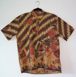 Authentieke Balinese batik blouse met korte mouw en mandarijnen boord. Wordt op de broek gedragen. Met zijsplitjes van 11 cm. Wijdte 112 cm. Lengte 65 cm. Schouderbreedte 49,5 cm. 100% katoen. Ned. maat 56.