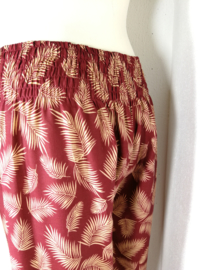 Broek Bali blad roest/zand. Met breed elastiek in taille/ heupband en elastiek in de enkels. Binnenbeenlengte 83 cm, taille tot 94 cm. Ruimvallende pijp en normale hoogte kruis. 100% rayon. Maat 36 t/m 42.