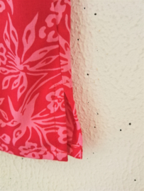 Lief shirtje van batik in roze tinten. Met mouwtje en zijsplitjes. Sluit met knoopje achter. Maat 140-146. 100% rayon.
