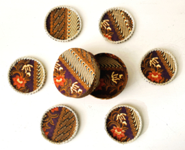 Set onderzetters. Stoffen batik doosje met 6 stoffen onderzetters, afgewerkt met rotan. Schitterend handwerk.