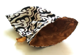 Wit/bruin batik offerzakje. Gevoerd met licht karamel kleurige satijn. Met karamel aantreklintje.  Printjes kunnen verschillen.