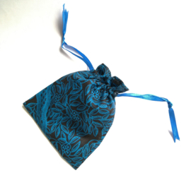 Turquoise/zwart batik offerzakje. Gevoerd met blauwkleurige satijn. Met blauw aantreklintje.