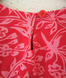 Lief shirtje van batik in roze tinten. Met mouwtje en zijsplitjes. Sluit met knoopje achter. Maat 140-146. 100% rayon.