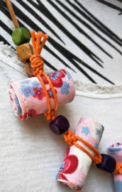 Halsketting met zes mini opgerolde batik sarongs en houten kralen. Met verstelbaar koord.