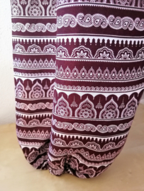 Broek 'Al Wakra' bordeaux/wit . Met breed elastiek in taille/ heupband, sierkoordje aan voorzijde, opgestikt zijvakje en elastiek in enkels. Ruimvallende pijpen en normale hoogte kruis. 100% rayon. Binnenbeenlengte  74 cm Maat 44 t/m 50.