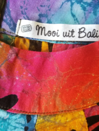 Prachtig handwerk van eigen label. Vrolijk libelle regenboogjurkje. Gemaakt van speciale BingBatik. Mouwloos modelletje met stolpplooien vanuit de halslijn. Sluit met een tweetal knoopjes achter. Voor 6-8 jaar. 100% rayon, wasbaar op 30  graden.