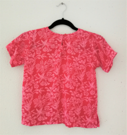 Lief shirtje van batik in roze tinten. Met mouwtje en zijsplitjes. Sluit met knoopje achter. Maat 140-146. 100% rayon.