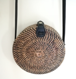 Zwart/goud rotan tasje.  Subliem afgewerkte sluiting en draagband van zwart leer. Lengte band 1.27 cm. Sluit met stevige drukknoop. Diameter 20 cm. 7,5 cm diep.