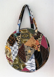 Unieke patchwork Mandala schouder tas, dubbel doorgestikt. Diameter 46 cm, hoofdvak met dubbele rits en voorvak met diameter van 25 cm en enkele rits. Lengte band 39 cm.