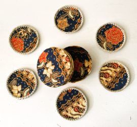 Set onderzetters. Stoffen batik doosje met 6 stoffen onderzetters, afgewerkt met rotan. Schitterend handwerk.