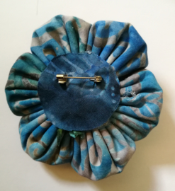 Prachtige bloem corsage/broche van batik stof met kokos knoopje. Diameter 7 cm.