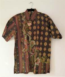 Authentieke Balinese batik blouse met korte mouw en  knoopsluiting. Wordt op de broek gedragen. Met zijsplitjes van 11 cm. Wijdte 112 cm. Lengte 73 cm. Schouderbreedte 50 cm. 100% katoen. Ned. maat 54.