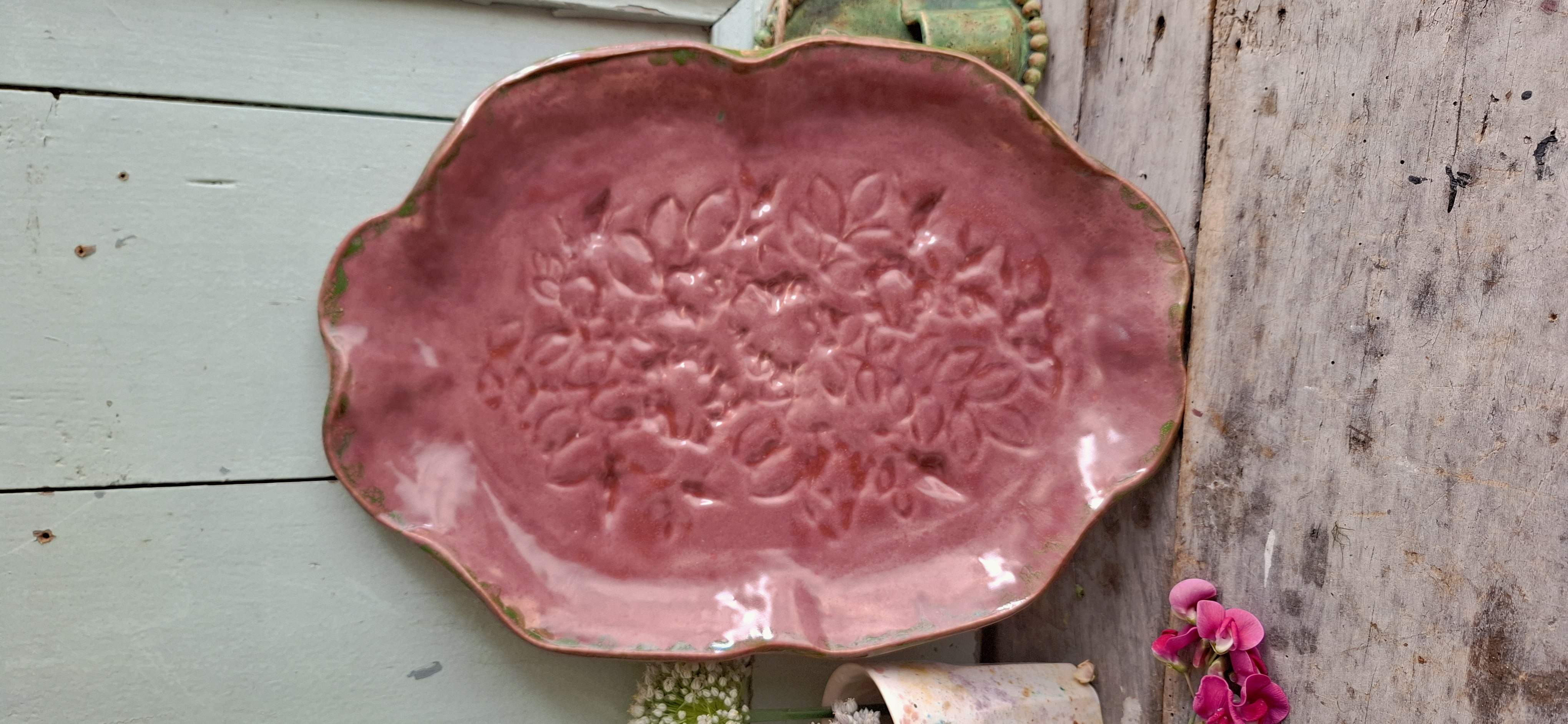Groot oud roze bord met bloemenmotief