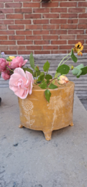 Goudkleurige flowerbrick op pootjes met ingekraste bloemen.