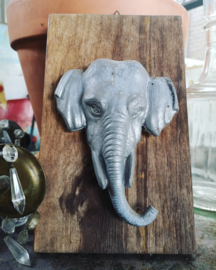 Old tin elephant on wooden plate