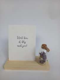 Kaart of glas met tekst - op houten blokje met een flesje droogbloemen