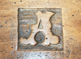 Antieke voetenstoof met initialen