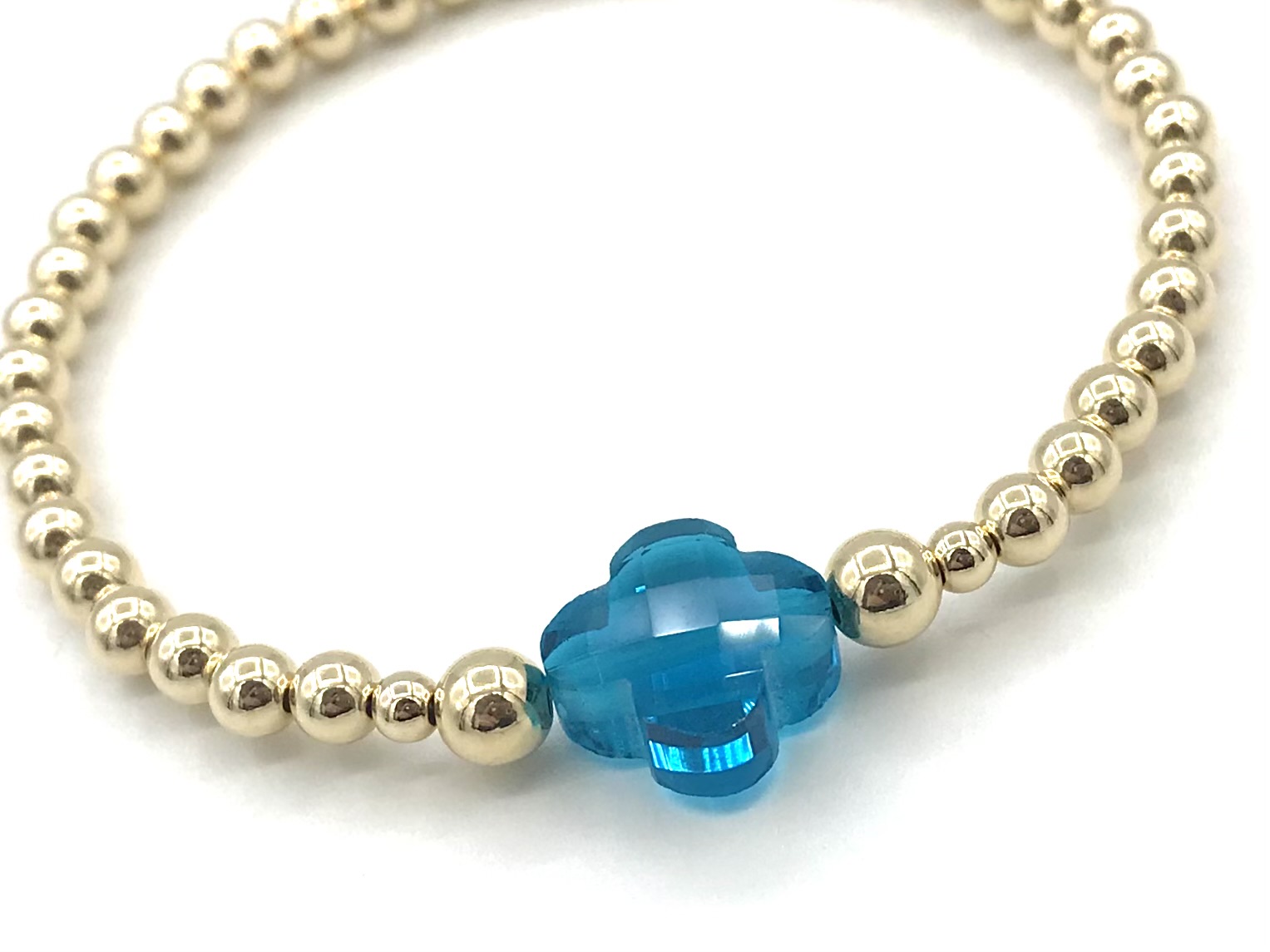 Armband Lizzie aqua met goudkleurige real gold plated balletjes en blauw klavertje
