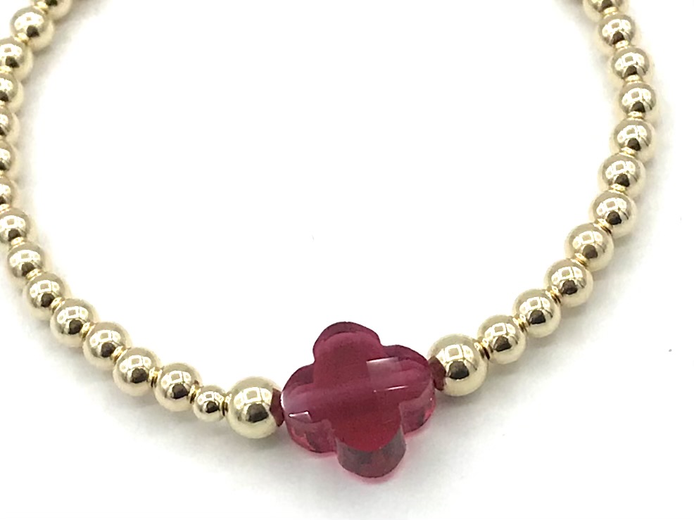 Armband Lizzie fuchsia met goudkleurige real gold plated balletjes en roze klavertje