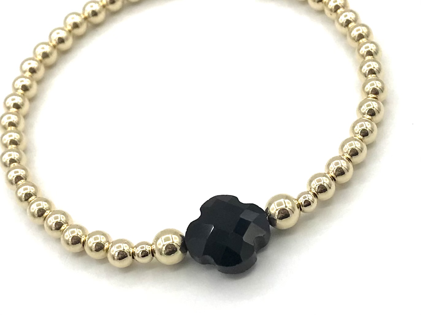 Armband Lizzie black met goudkleurige real gold plated balletjes en zwart klavertje