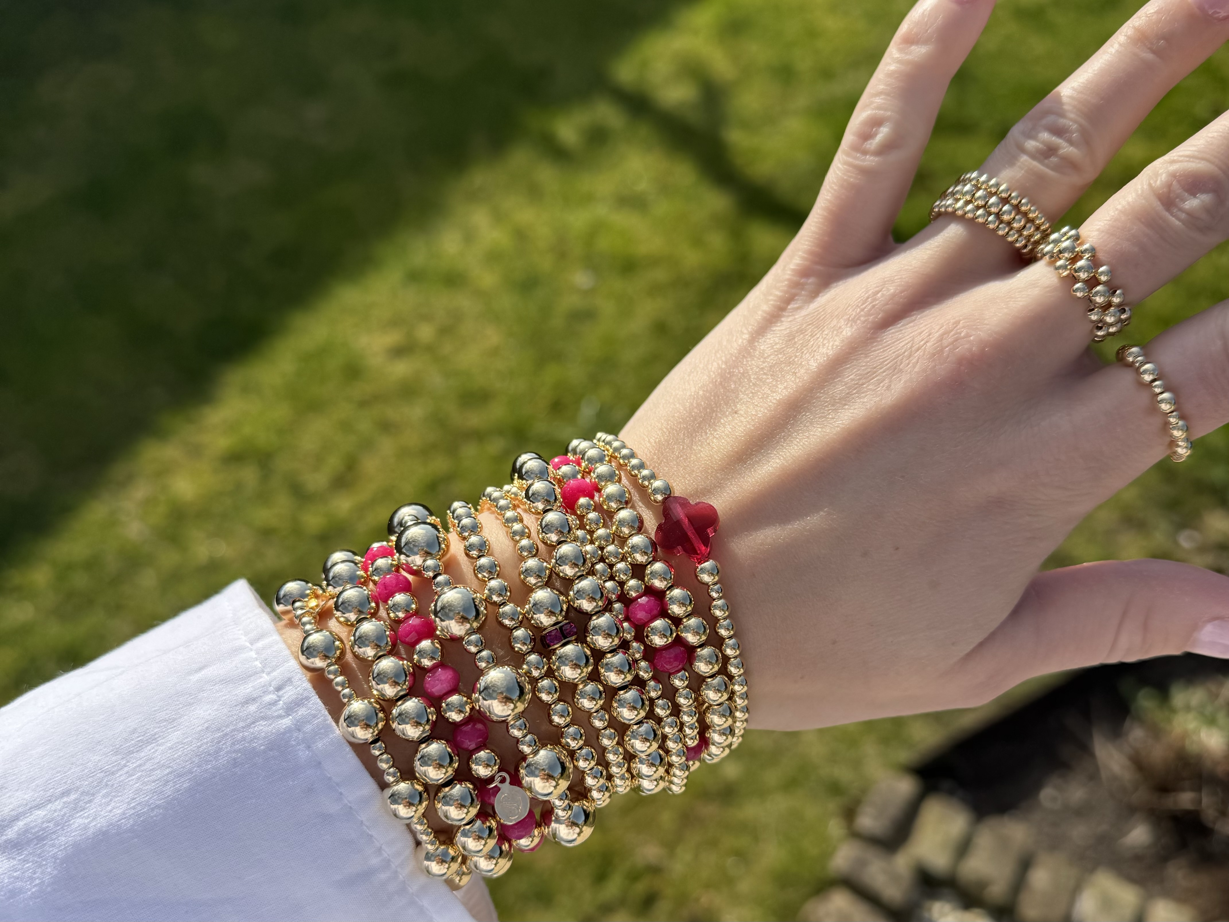 Armband Lizzie fuchsia met goudkleurige real gold plated balletjes en roze klavertje