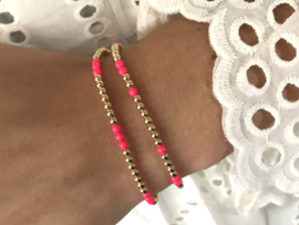 Armband Mirte met real gold plated balletjes en neon roze Swarovski pareltjes