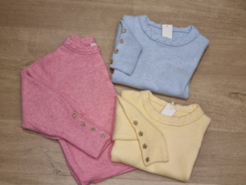 zachte trui met gouden bloemenknopjes aan de pols lichtblauw