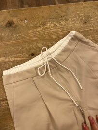 Beige pantalon met wit boordje aan de bovenkant met vetersluiting