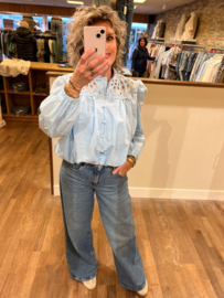 Blouse baby blauw met opengewerkte stof bovenkant elastiek aan de onderkant