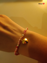 Roze glaskralen armband met bedeltje.