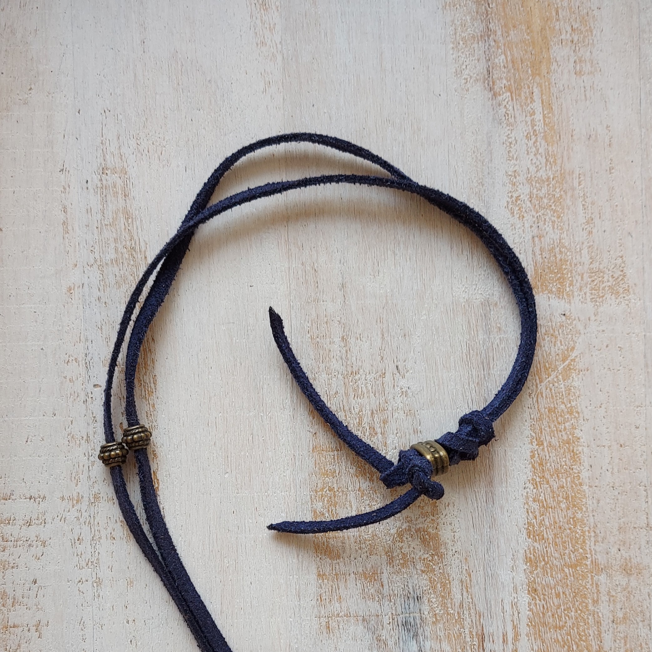 Blauw suède ketting met bronskleurige hanger