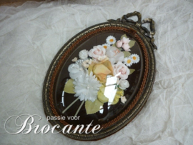 Vintage kader met strik en bloemen onder gebombeerd glas