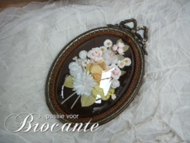 Vintage kader met strik en bloemen onder gebombeerd glas