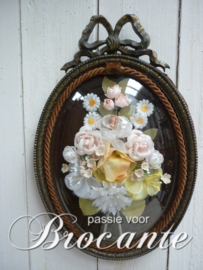 Vintage kader met strik en bloemen onder gebombeerd glas