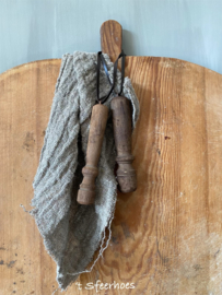 oude doorleefde houten klos aan leren veter, links